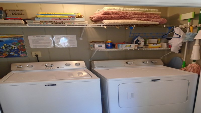 New Maytag washer and dryer, and board games and other amenities on the shelves.