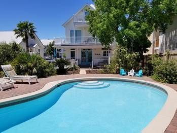 Good sized pool with lounge chairs and dining tables.